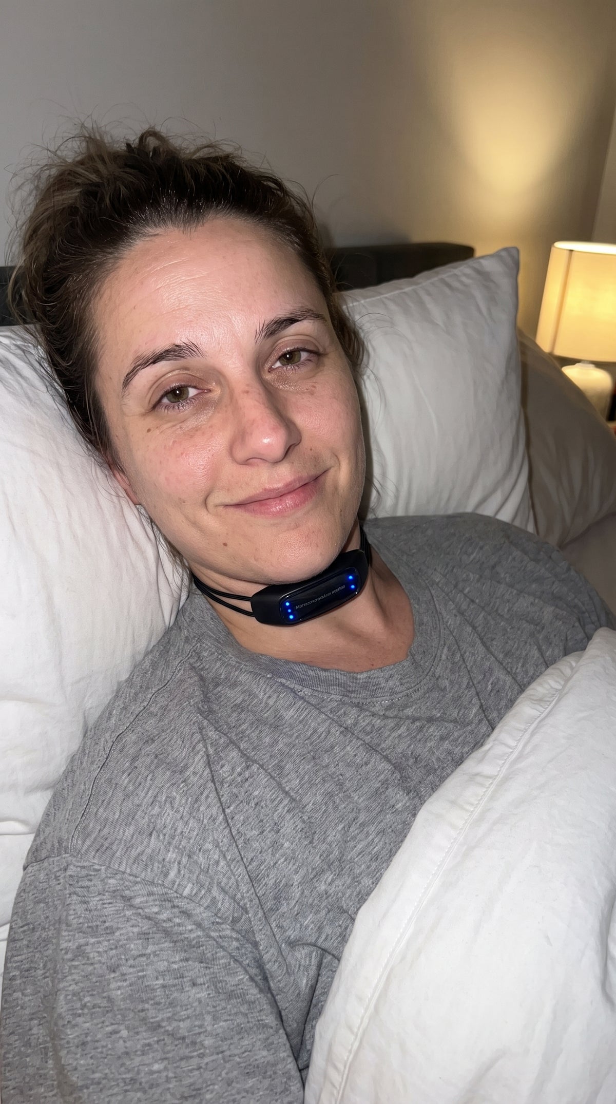 Mujer en la cama con el dispositivo antirronquidos puesto